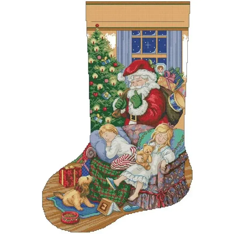 While They Sleep (KB177) Christmas stocking cross stitch design KB177: Santa laying out gifts while two children sleep in an armchair with their puppies in a warm firelit room
