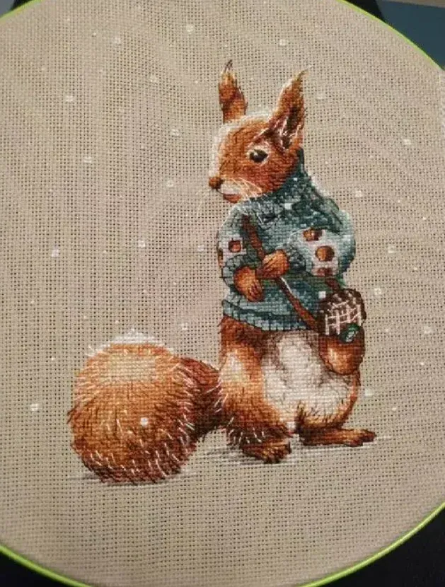 Finished Squirrel design DPD273 stitched by a buyer, still on the embroidery hoop: a red squirrel in a teal sweater on flaxen fabric