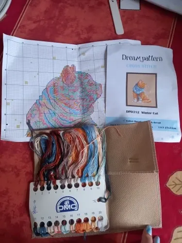 A finished small-animal counted cross stitch project from a CozyCross kit, stitched on flaxen Aida fabric